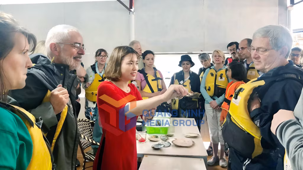 Khách du lịch tìm hiểu về quy trình nuôi trai lấy ngọc ở làng chài Vùng Viêng, TP Hạ Long (4-2019). Ảnh: Bảo Bình