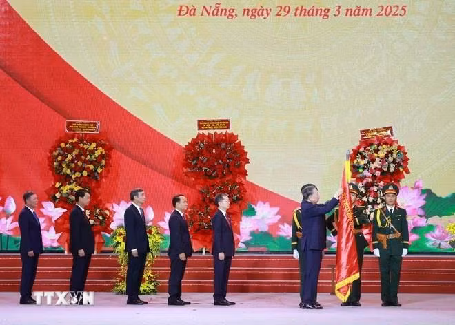 Tổng Bí thư Tô Lâm gắn Huân chương Lao động hạng Nhất lên Cờ truyền thống của Thành phố Đà Nẵng. (Ảnh: TTXVN)