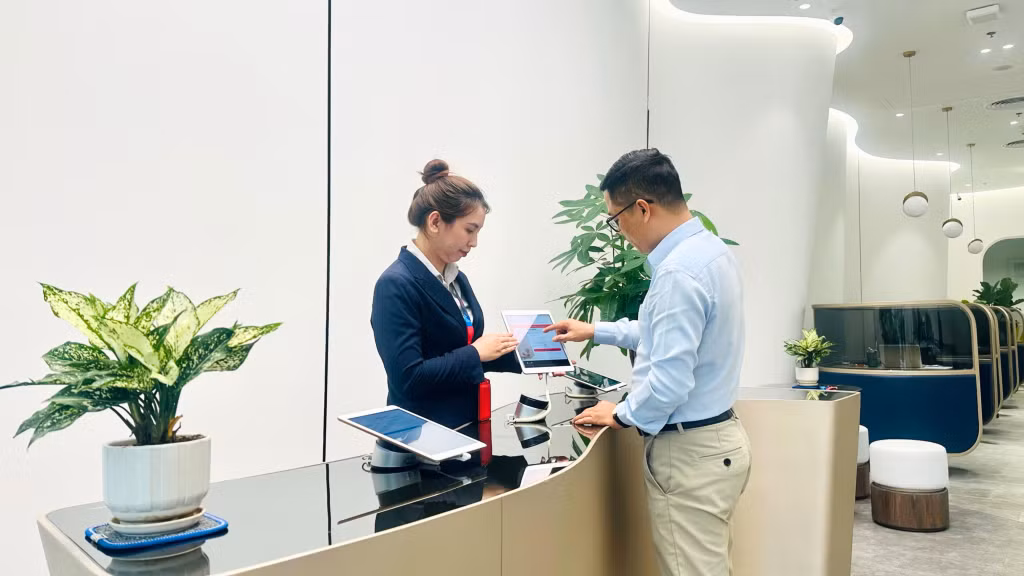 Nhân viên hướng dẫn khách hàng thực hiện giao dịch.