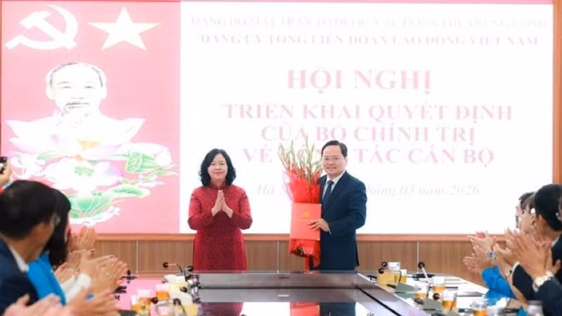 Đồng chí Bùi Thị Minh Hoài trao hoa tặng đồng chí Nguyễn Anh Tuấn.