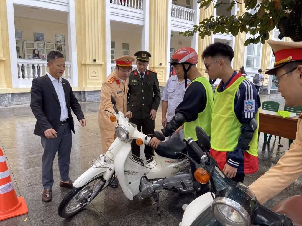 Các em học sinh Trường THPT Hòn Gai được hướng dẫn một số thao tác kỹ thuật, làm quen với phương tiện trước khi thực hành. Ảnh: Bùi Thế Chinh - Phòng Cảnh sát giao thông (Công an tỉnh).