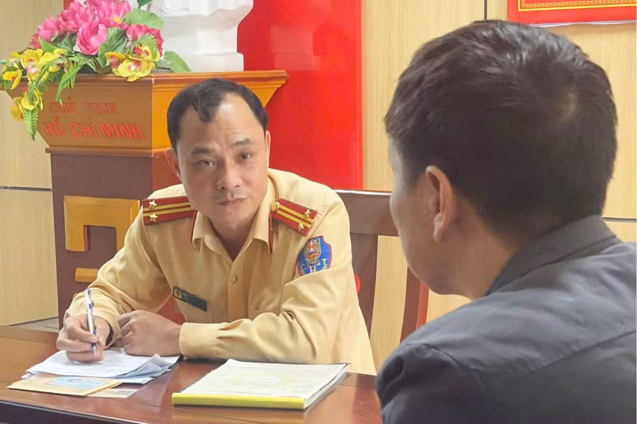 Cán bộ CSGT Công an tỉnh Nghệ An lập biên bản tài xế xe đầu kéo có hành vi kéo theo xe tự chế phía sau. Ảnh: Ngọc Anh