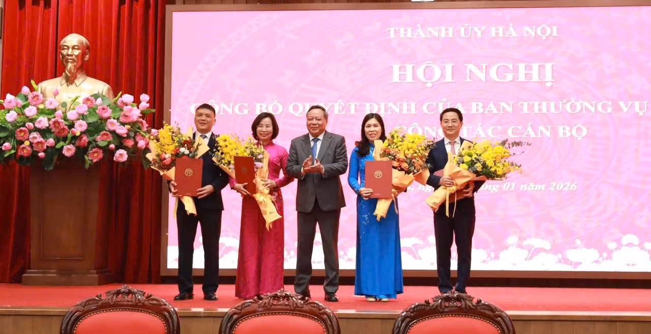 Phó bí thư thường trực Thành ủy Hà Nội Nguyễn Văn Phong tặng hoa chúc mừng các cán bộ nhận quyết định. Ảnh: Trần Hoàng