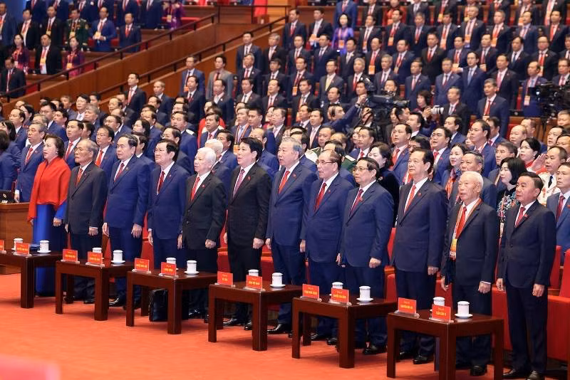 Các đồng chí lãnh đạo, nguyên lãnh đạo Đảng, Nhà nước và đại biểu thực hiện nghi lễ chào cờ. Ảnh: TTXVN