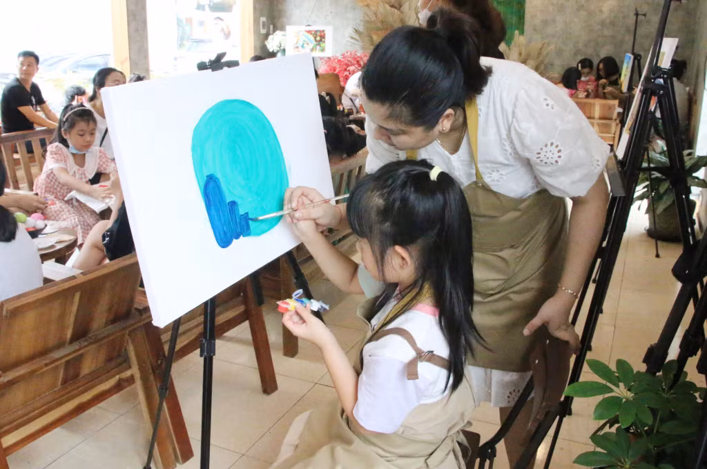 Chị Nguyễn Lan Phương, Chủ nhiệm CLB 14 Art, hướng dẫn các bạn nhỏ vẽ tranh màu nước.