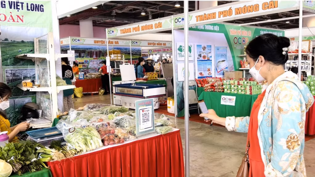 Người dân quét mã thanh toán khi mua sắm tại Hội chợ OCOP Quảng Ninh Hè 2022.