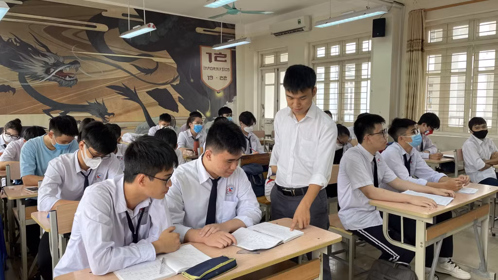 Vũ Huy Hoàng (ngồi bàn đầu, thứ 2, từ trái sang) luôn được thầy cô, bạn bè đồng hành, hỗ trợ trong quá trình học tập.