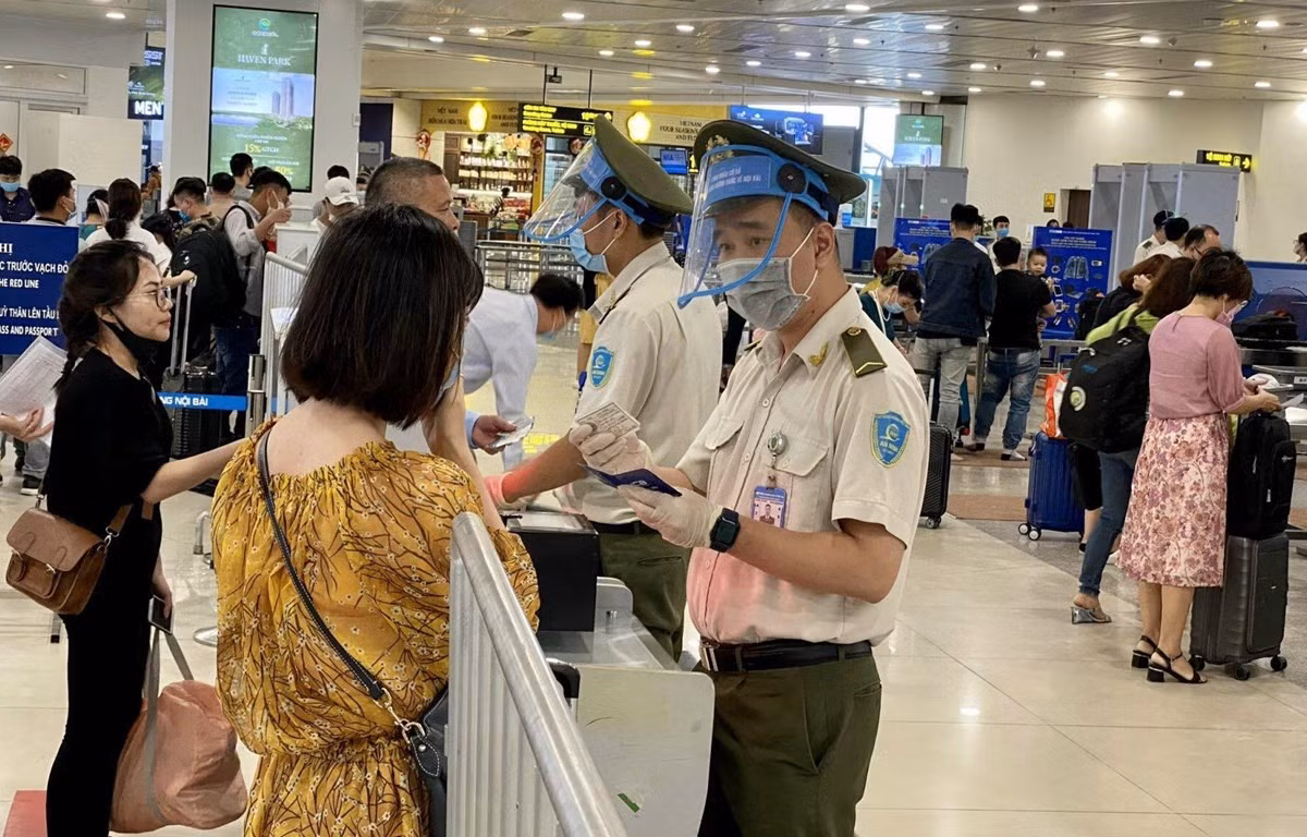 Lực lượng An ninh hàng không Nội Bài được trang bị đầy đủ găng tay, khẩu trang, tấm chắn giọt bắn trong khi tiếp xúc với hành khách. (Ảnh: CTV/Vietnam+)