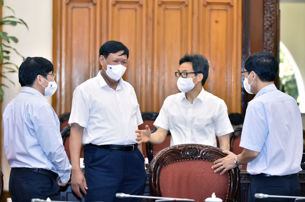 Phó Thủ tướng Vũ Đức Đam trao đổi với lãnh đạo Bộ Y tế về tình hình dịch bệnh. - Ảnh: VGP/Nhật Bắc