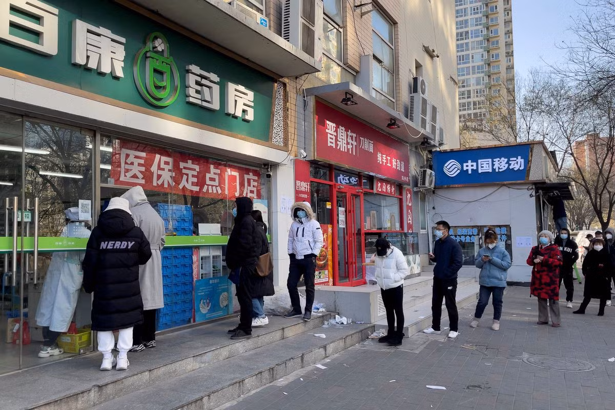 Người dân đeo khẩu trang xếp hàng bên ngoài một hiệu thuốc ở Bắc Kinh. Ảnh: Reuters