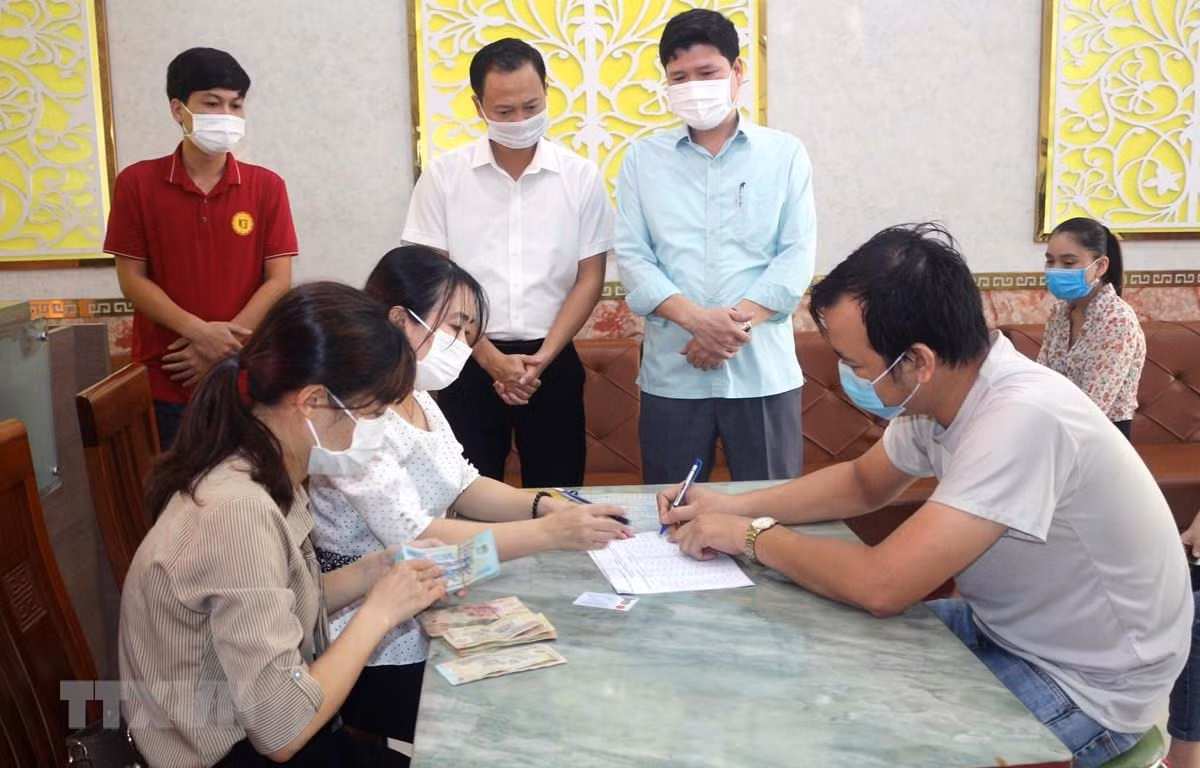 Chi trả tiền hỗ trợ cho người lao động bị ảnh hưởng bởi COVID-19. (Ảnh minh hoạ: Đại Nghĩa/TTXVN)