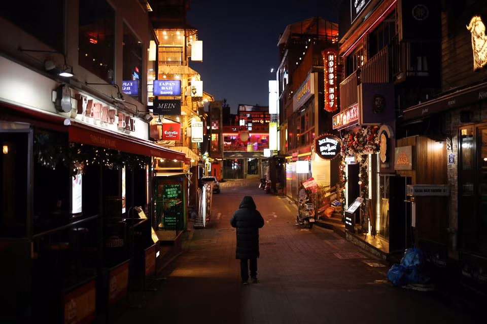 Một người đàn ông đi bộ trên một con phố vắng ở Itaewon, gần nơi xảy ra vụ giẫm đạp lễ Halloween, ngày 18/12/2022. Ảnh: Reuters