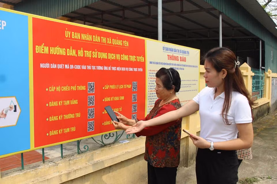 Cán bộ phường Yên Giang (TX Quảng Yên) hướng dẫn người dân quét mã QR tại Nhà văn hóa khu phố 1.