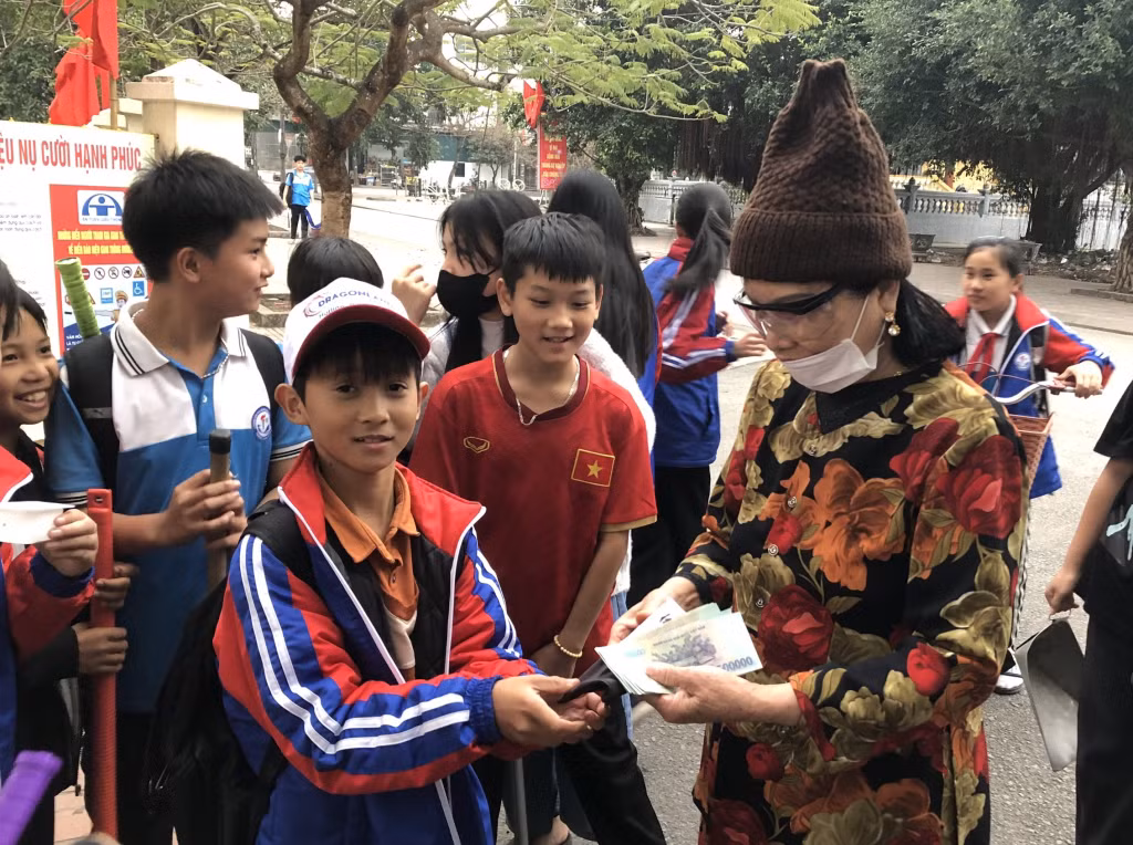 Em Nguyễn Văn Khôi, lớp 6E, trường THCS Hà An, trao trả lại chiếc túi và toàn bộ số tiền cho bà Vũ Thị Nhặt.