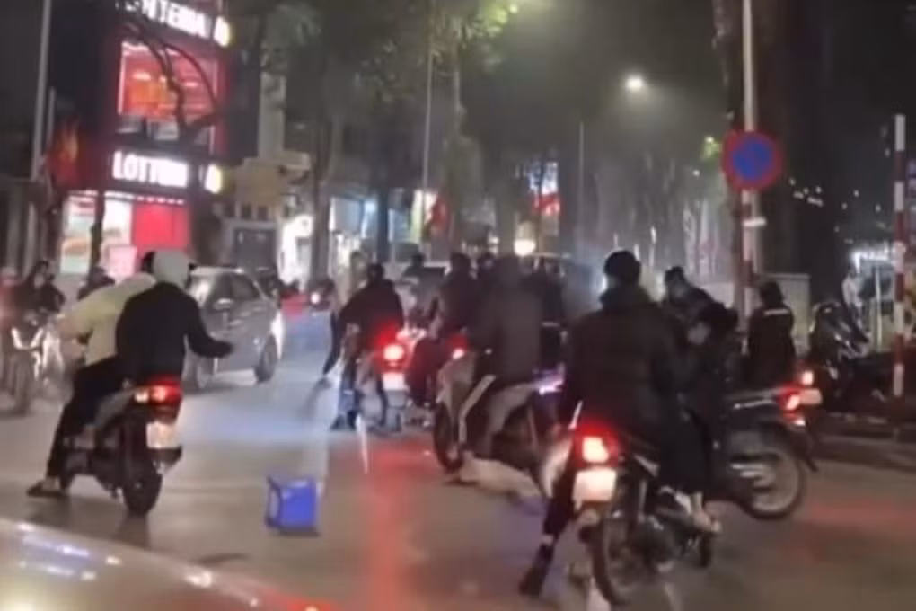 Nhóm thanh, thiếu niên cầm ghế nhựa lao vào tấn công người khác (Ảnh: Hoàng Tuấn).