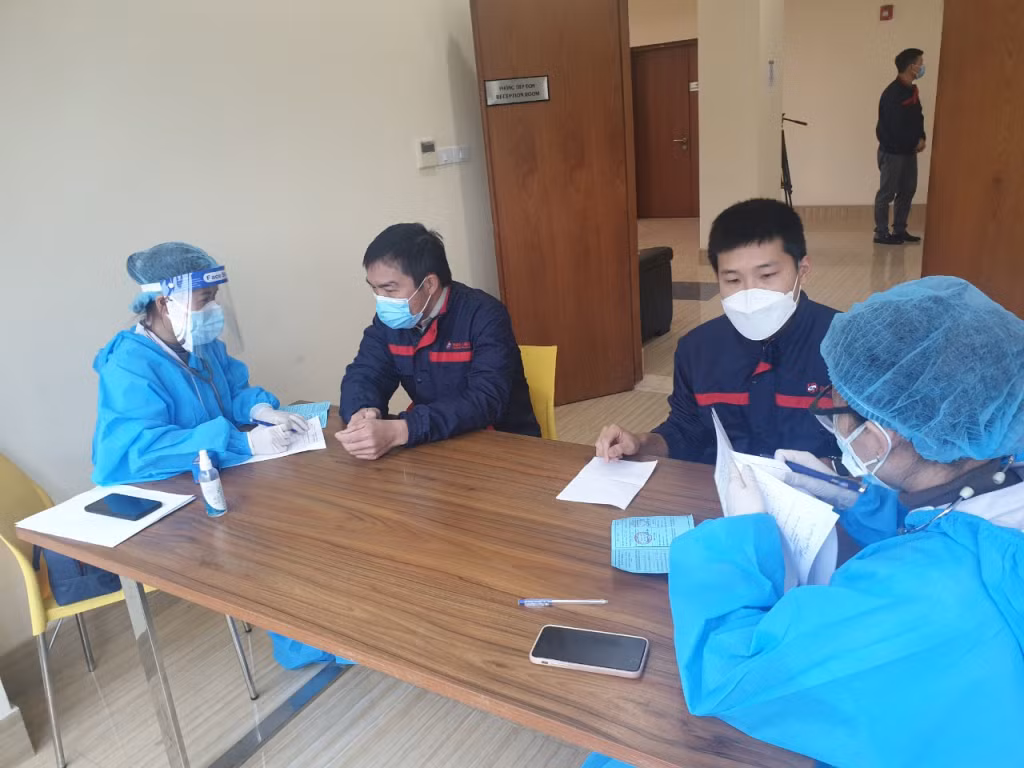 CBCNLĐ Nhà máy Nhiệt điện Thăng Long được khám sàng lọc trước khi tiêm vắc-xin phòng Covid-19 mũi 3 (mũi tăng cường), ngày 3/1/2022.