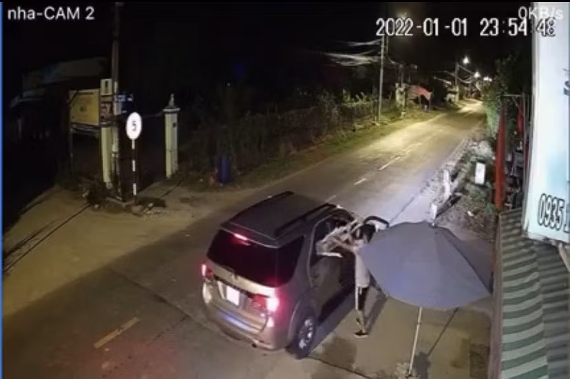 Đối tượng bê con chó đưa cho đồng bọn ngồi sau rồi lên xe tẩu thoát. Ảnh cắt từ clip.