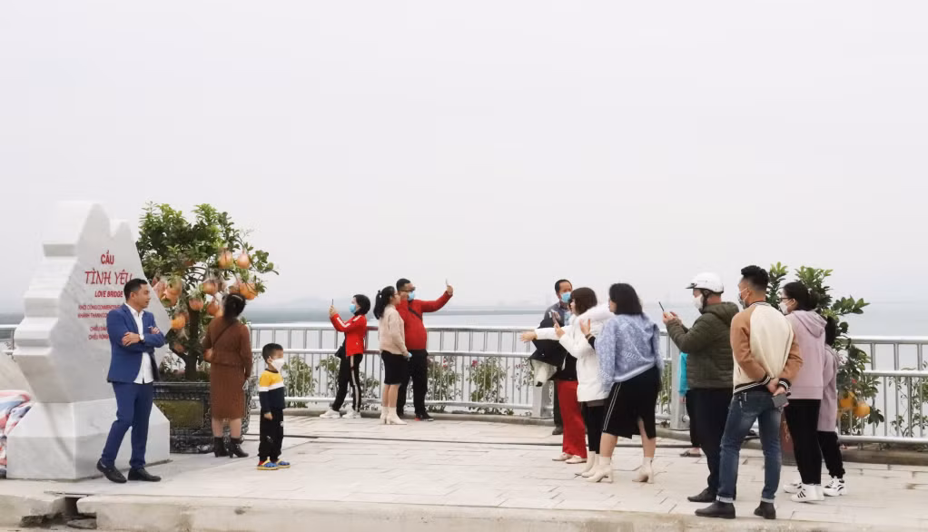 Hàng trăm người dân, du khách đã xếp hàng chờ đến lượt chụp ảnh trên cầu Tình Yêu, đảm bảo quy định 5K.