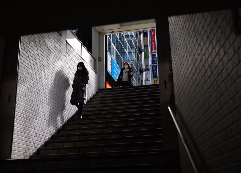 Người dân đeo khẩu trang đi xuống nhà ga tàu điện ngầm ở Tokyo, Nhật Bản. Ảnh: Reuters