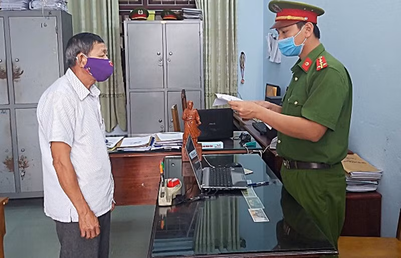 Cơ quan CSĐT Công an huyện Núi Thành thi hành các quyết định với Ngô Văn Phú. Ảnh: C.A