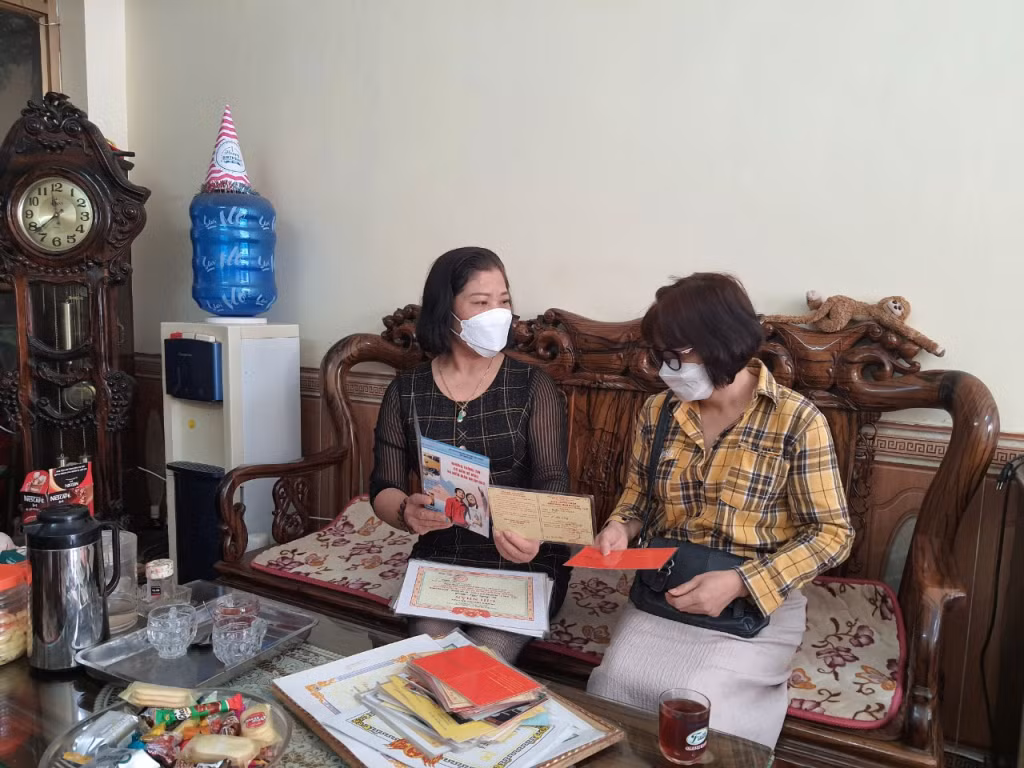 Chị Trần Thị Minh (trái) tuyên truyền, vận động hàng xóm tham gia hiến máu.