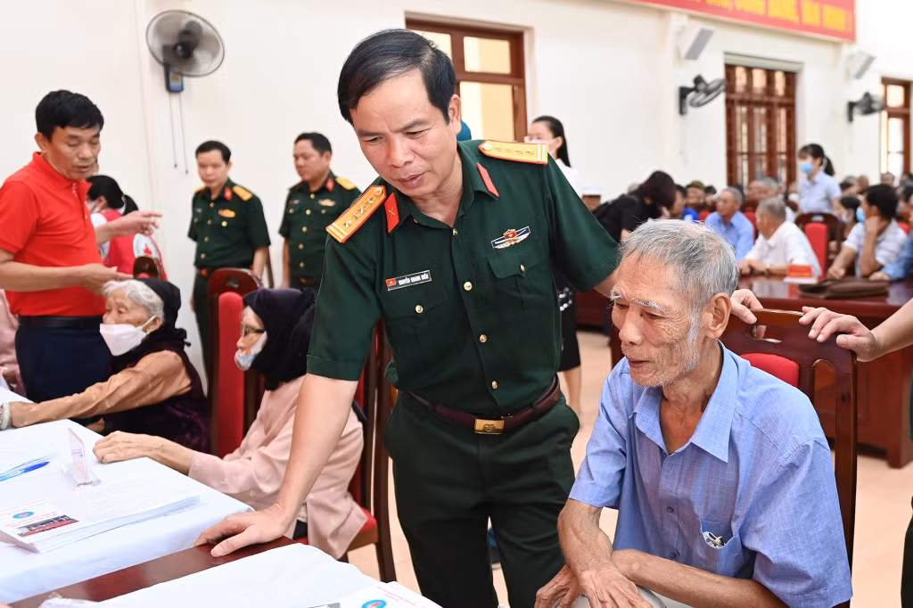 Đại tá Nguyễn Quang Hiến, Phó Bí thư Thường trực Đảng ủy, Chính ủy Bộ CHQS tỉnh, ân cần thăm hỏi sức khỏe các đối tượng chính sách tại buổi khám bệnh, cấp phát thuốc miễn phí cho người dân TX Quảng Yên.