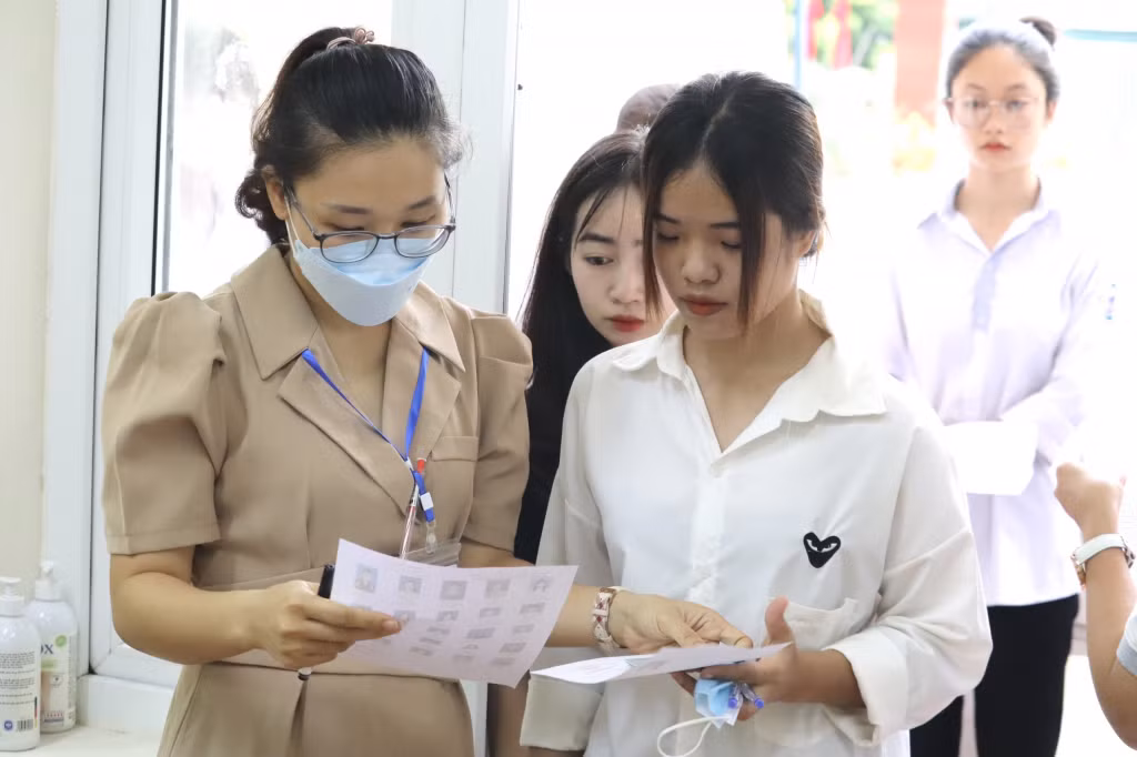 Cán bộ coi thi Điểm thi THPT Bạch Đằng (TX Quảng Yên) kiểm tra thẻ dự thi của thí sinh. Ảnh: Minh Đức
