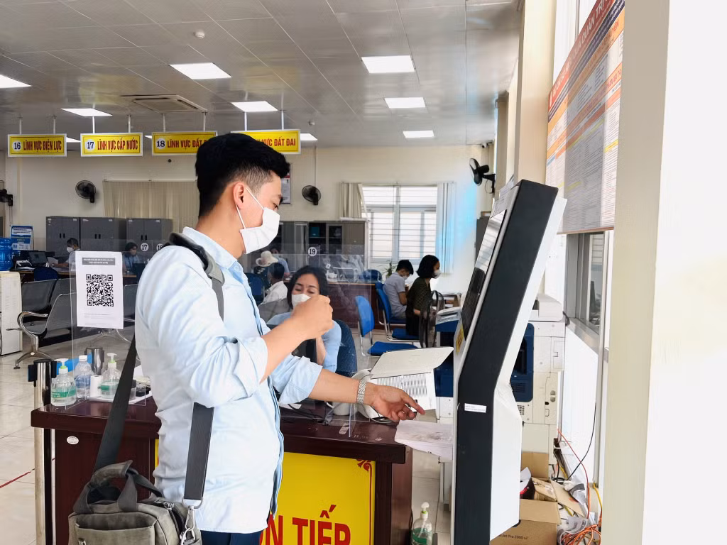 Người dân lấy số thứ tự tự động tại Trung tâm hành chính công thị xã Đông Triều.