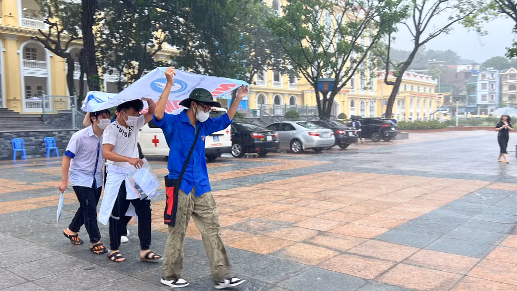 Cơn mưa lớn trên địa bàn TP Hạ Long và một số địa phương ngay thời điểm các thí sinh hoàn tất môn thi đầu tiên gây không ít khó khăn cho việc di chuyển của thí sinh. Lực lượng thanh niên tình nguyện đã có mặt, hết mình trợ giúp, che mưa cho thí sinh.