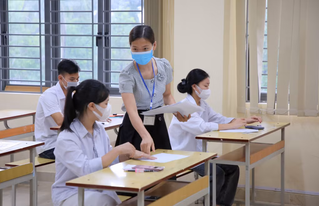 Cán bộ làm thi phát giấy nháp cho thí sinh.