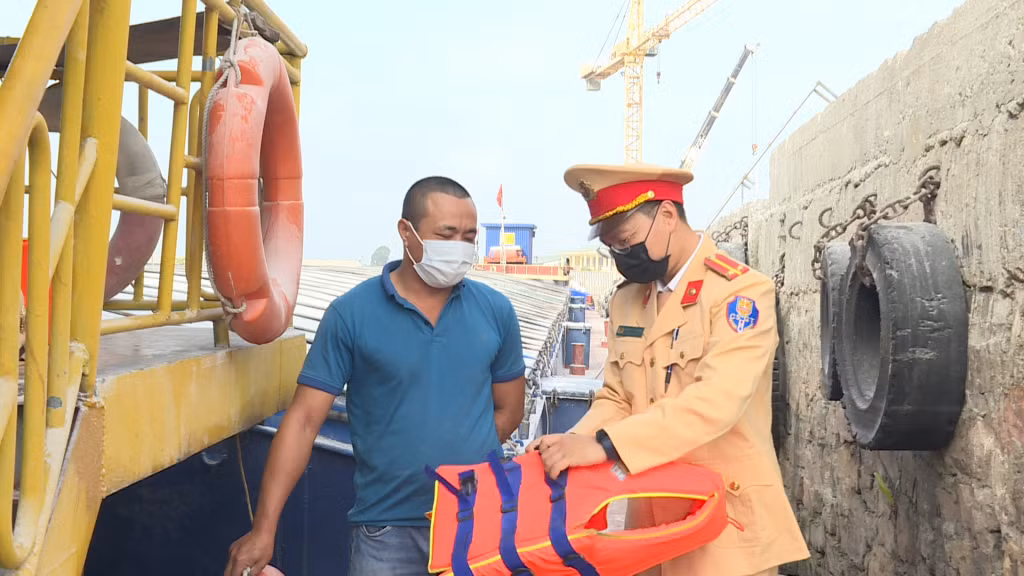 Công an TP Móng Cái hướng dẫn thuyền viên sử dụng áo phao đúng cách.