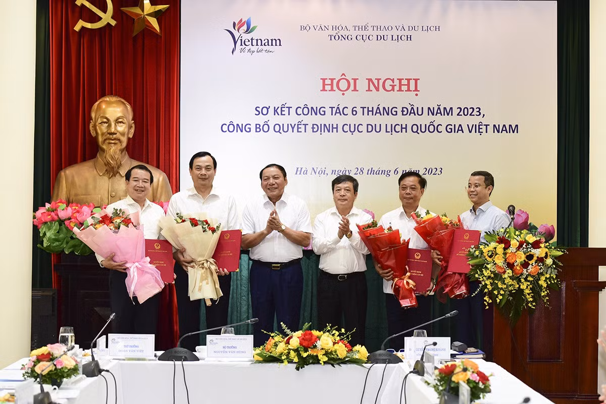 Bộ trưởng Nguyễn Văn Hùng và Thứ trưởng Đoàn Văn Việt trao Quyết định và tặng hoa chúc mừng các đồng chí giữ chức vụ lãnh đạo Cục Du lịch Quốc gia Việt Nam từ 1/7/2023. Ảnh: TITC