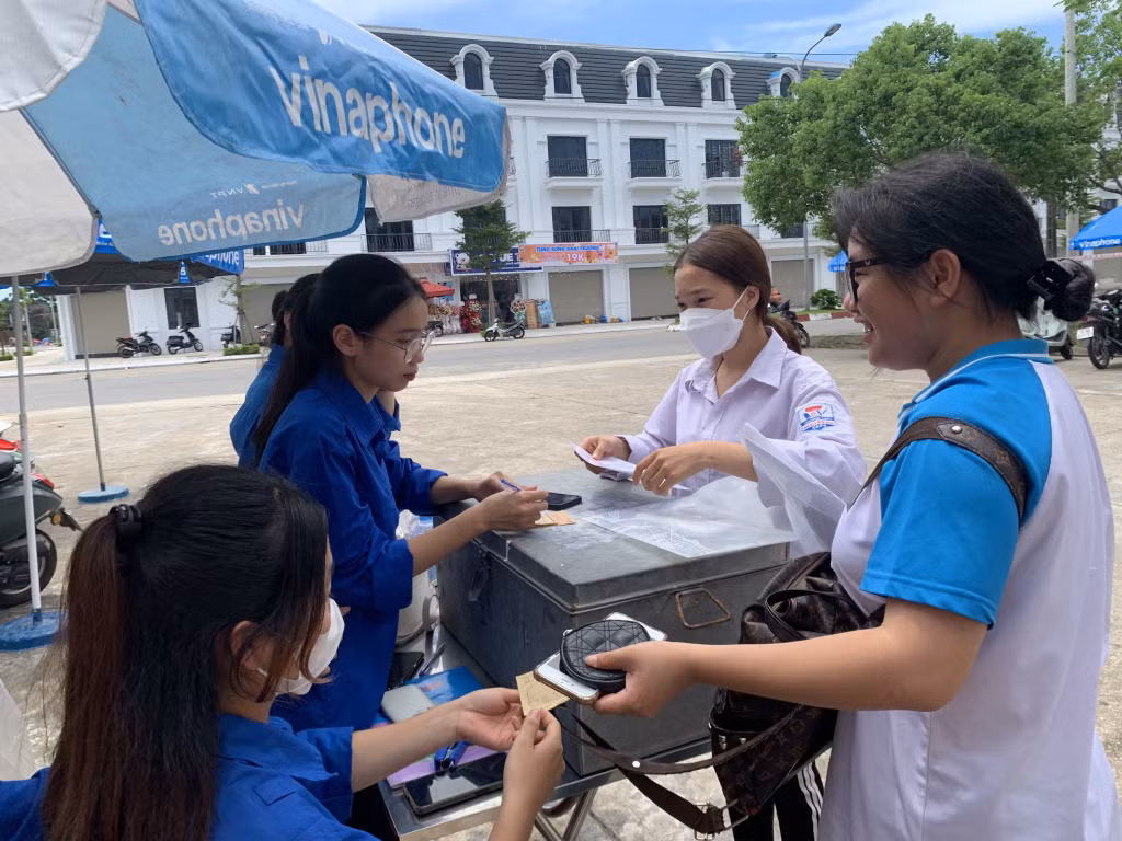 Đoàn viên thanh niên huyện Hải Hà hỗ trợ thí sinh giữ đồ trước khi vào phòng thi. 