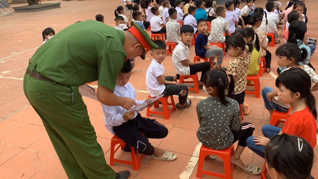 Công an xã Lương Mông (huyện Ba Chẽ) phát tờ rơi tuyên truyền phòng, chống ma túy cho học sinh. Ảnh: PL