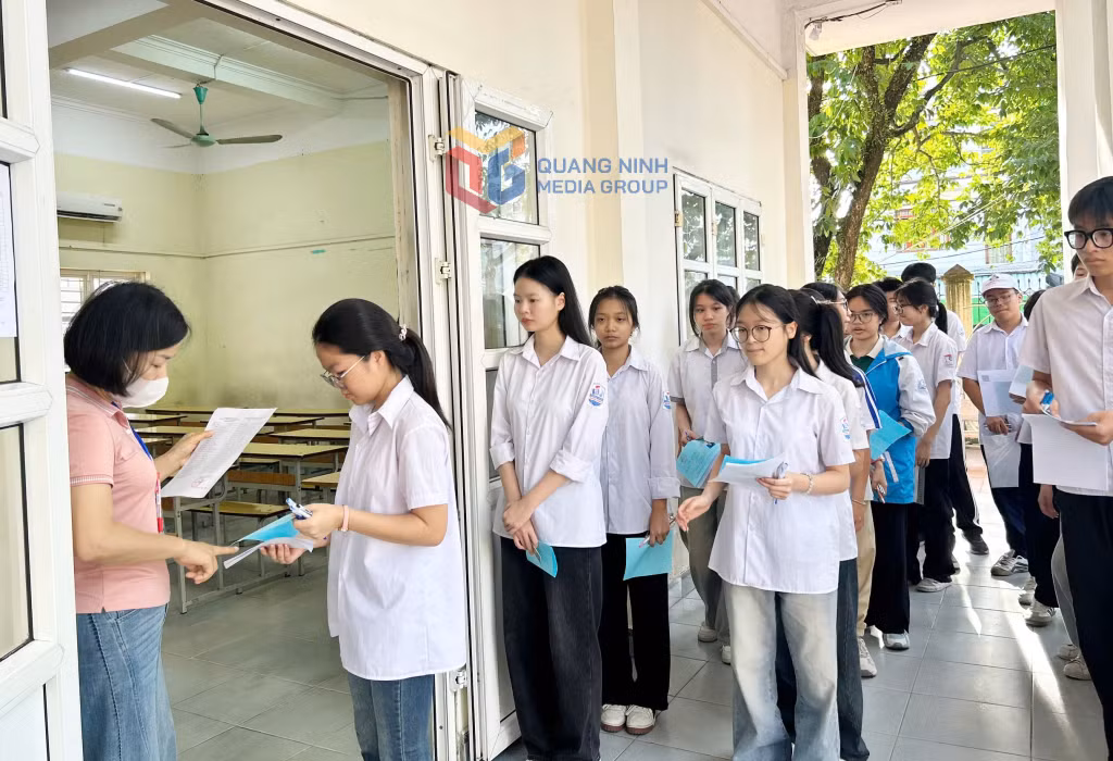 Cán bộ coi thi đọc tên và kiểm tra thông tin thí sinh trước khi vào phòng thi tại Hội đồng coi thi Trường THPT Lê Quý Đôn (TP Cẩm Phả).