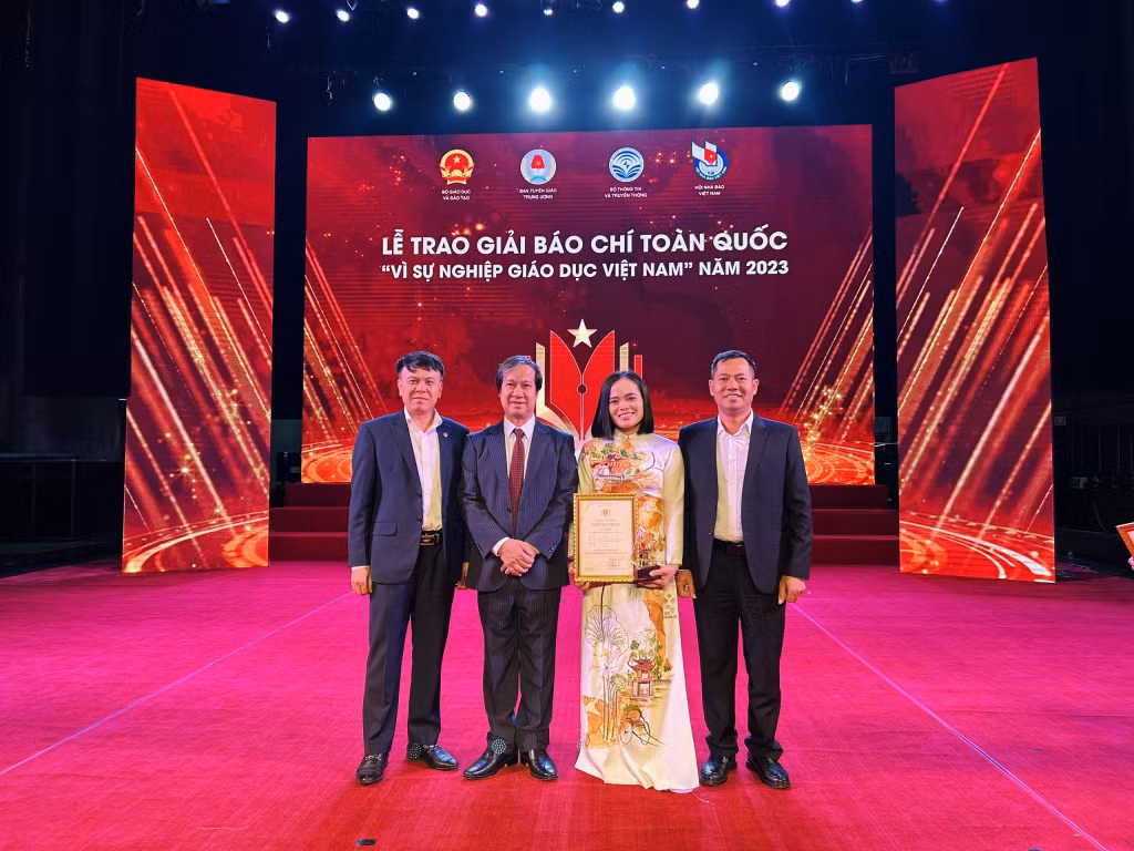 Phóng viên Thu Báu nhận giải ba từ Bộ trưởng Bộ GD - ĐT Nguyễn Kim Sơn trao tặng.