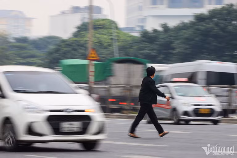 Người đàn ông bất chấp nguy hiểm băng qua dòng phương tiện trên đường Phạm Hùng