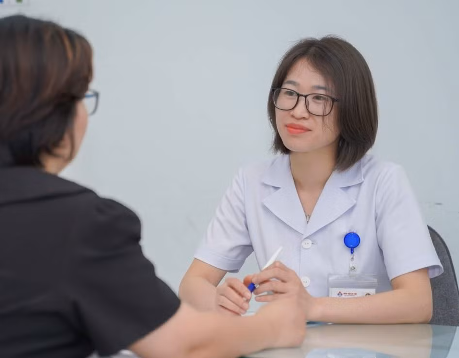 Bác sĩ Hà Tố Như tư vấn cho mẹ bệnh nhi về cách chăm sóc trẻ khi mắc viêm mũi họng cấp. Ảnh: Hải Phạm