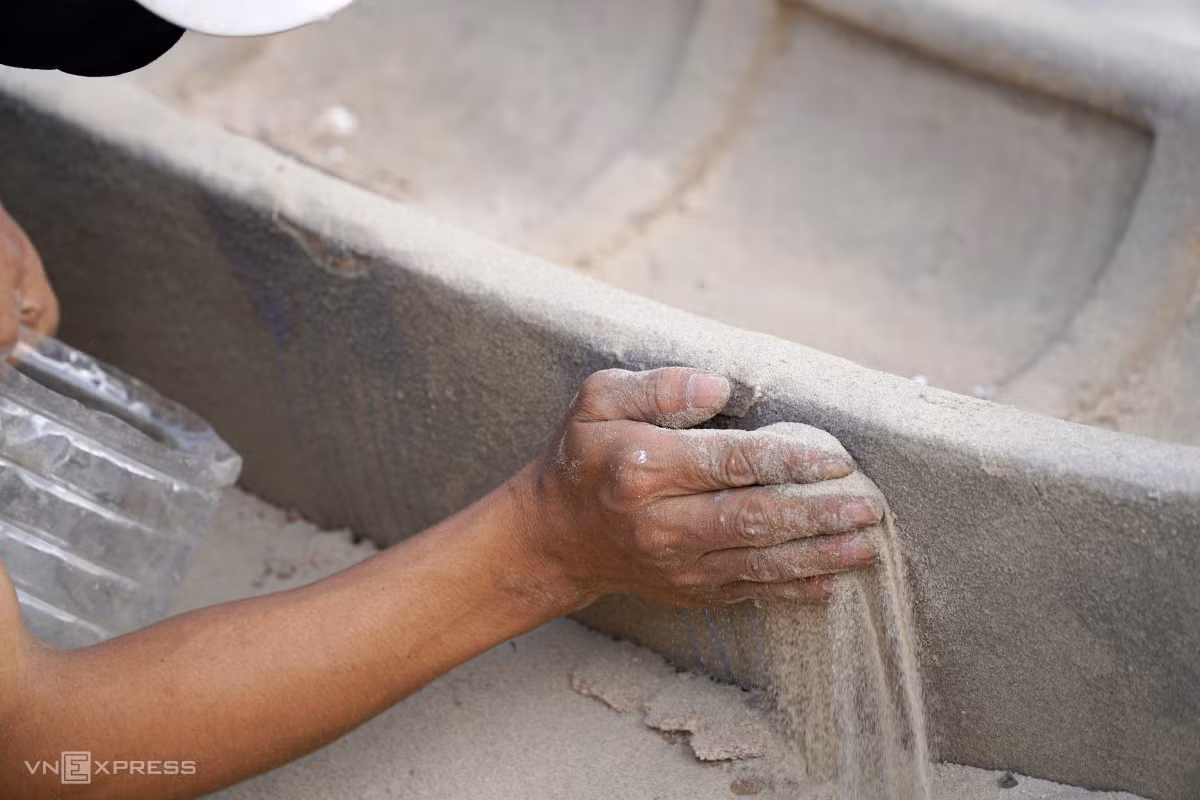 Nhân viên dùng cát gia cố vị trí hư hỏng trên một con thuyền nan.