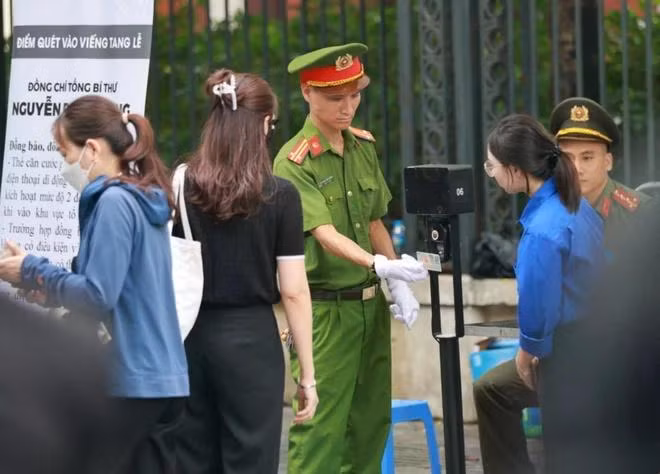 Lực lượng an ninh quét mã QR trên căn cước của người dân vào viếng Tổng Bí thư tại Nhà tang lễ Quốc gia. (Ảnh: TTXVN)