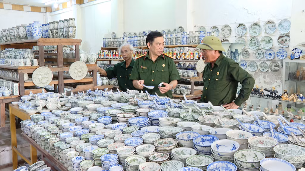 CCB Nguyễn Hải Đường (ngoài cùng, bên phải) giới thiệu với đồng đội về một số sản phẩm gốm sứ đặc trưng của HTX.