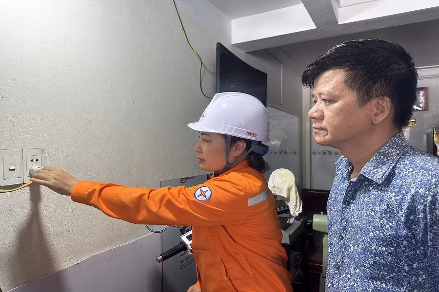 Công nhân Điện lực TP Hạ Long hướng dẫn khách hàng sử dụng điện, rút phích cắm ra khỏi nguồn điện đối với các thiết bị khi không sử dụng.