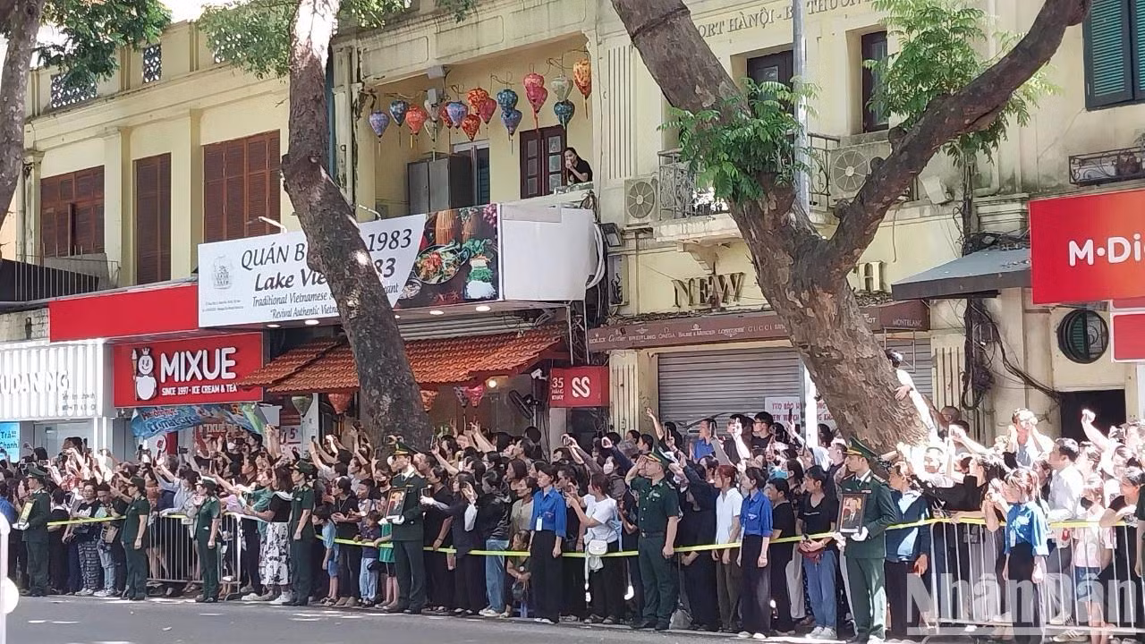 Người dân đứng ngay ngắn trên phố Hàng Khay chờ đoàn xe chở linh cữu của Tổng Bí thư Nguyễn Phú Trọng. (Ảnh: THANH NGA)