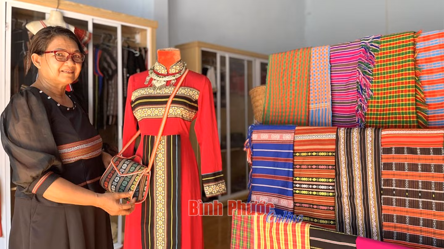 Nghệ nhân Thị Giôn bên những sản phẩm thổ cẩm của đồng bào S’tiêng