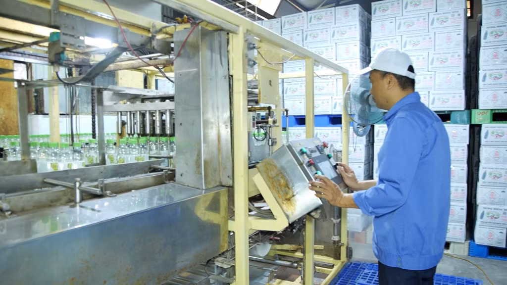 Công nhân vận hành dây chuyền sản xuất nước khoáng hiện đại.