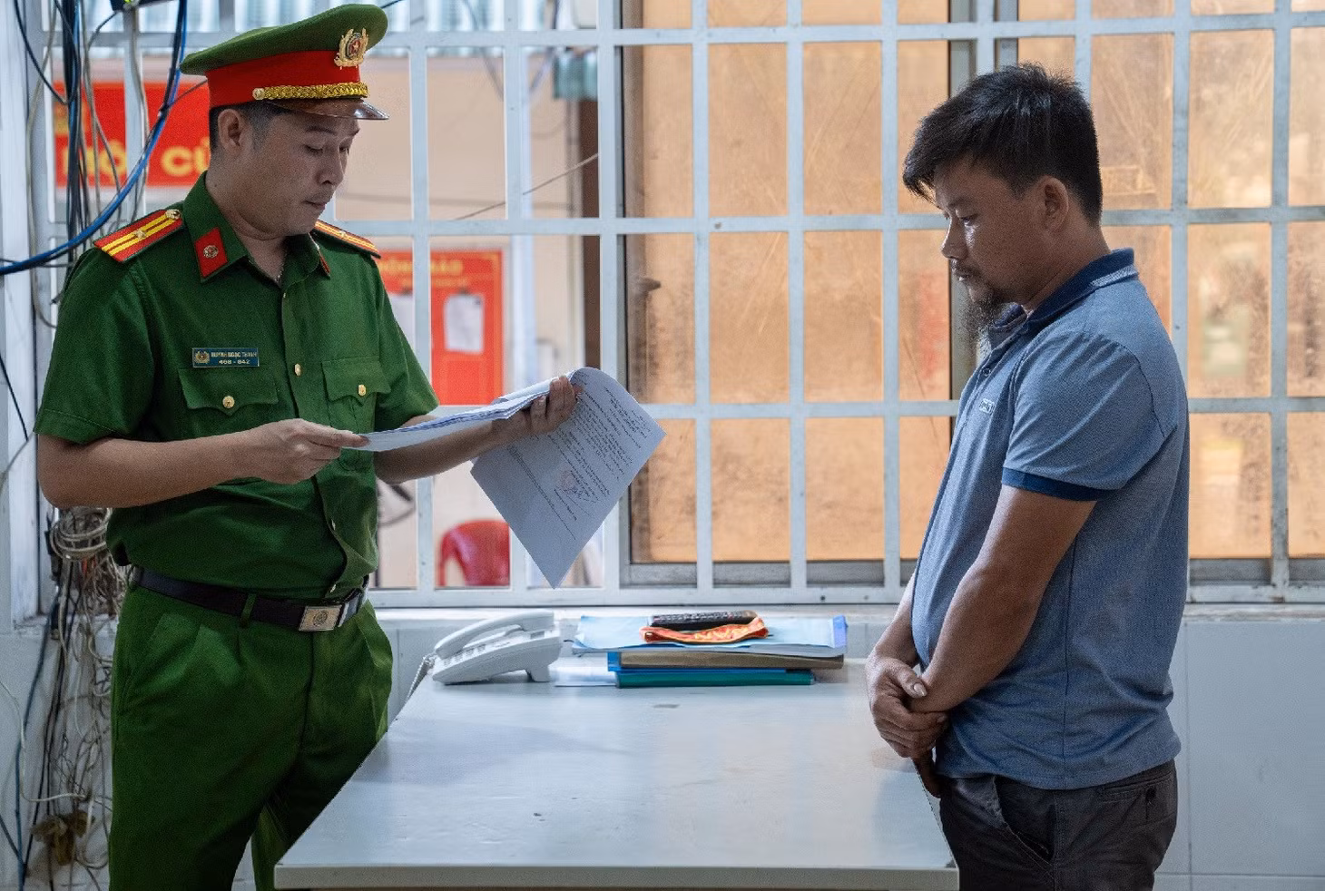 Cơ quan điều tra tống đạt quyết định khởi tố bị can đối với tài xế Tùng. Ảnh: Quang Hưng