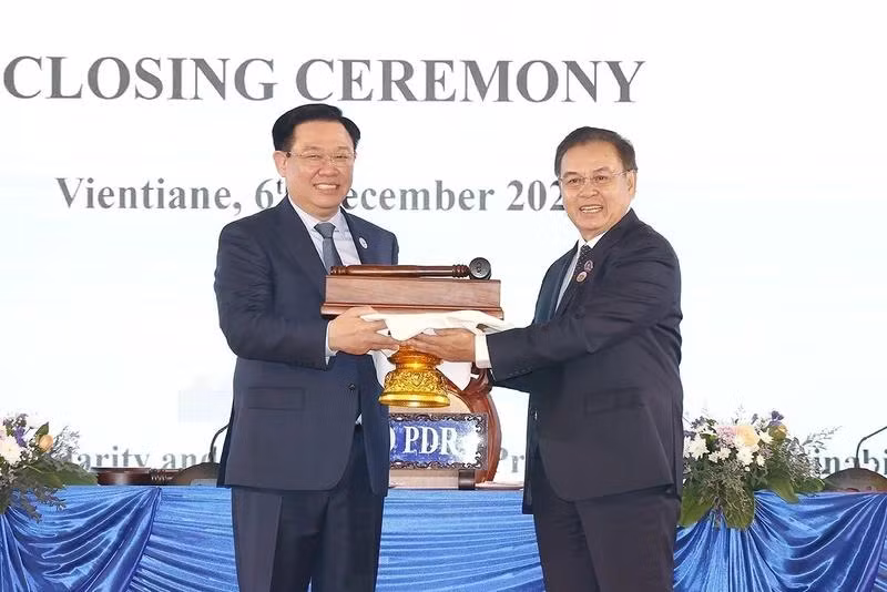 Chủ tịch Quốc hội Vương Đình Huệ nhận búa đảm nhận chức Chủ tịch Hội nghị cấp cao Quốc hội ba nước CLV lần thứ hai từ Chủ tịch Quốc hội nước Lào Saysomphone Phomvihane. (Ảnh: TTXVN)