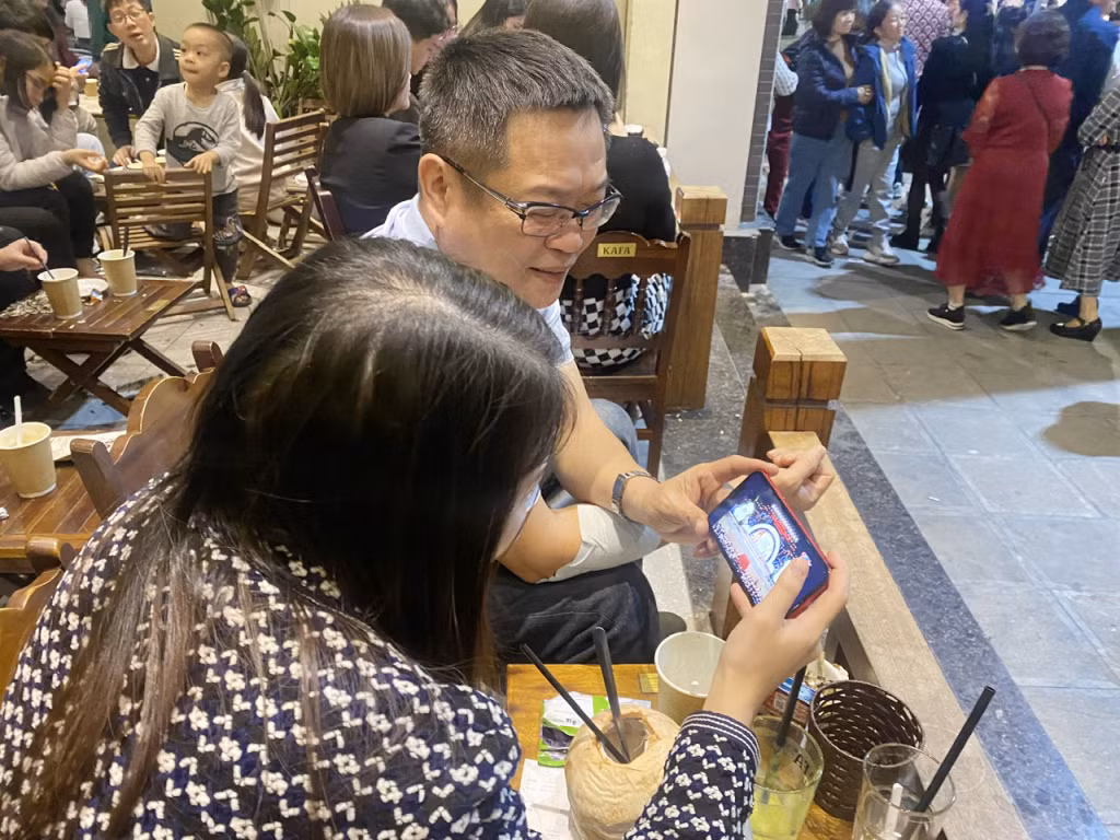 Người dân xem lễ kỷ niệm qua truyền hình trực tiếp trên sóng QTV.