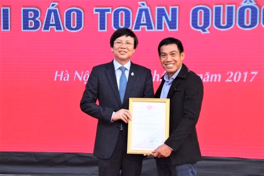 Nhà báo Vương Xuân Nguyên (bên phải) nhận vinh danh tại Hội Báo toàn quốc năm 2017.