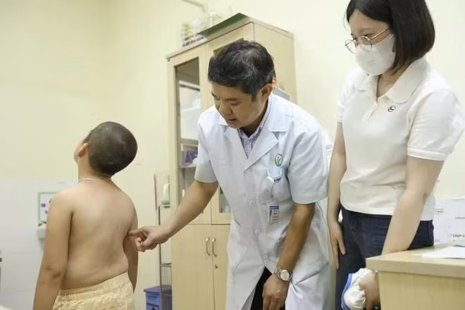 Bác sỹ khám, tư vấn cho bệnh nhi cong vẹo cột sống. (Ảnh: Minh Quyết/TTXVN)